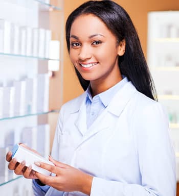 female pharmacist smiling while holding medicine