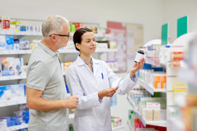 pharmacist showing a medicine to a senior man customer